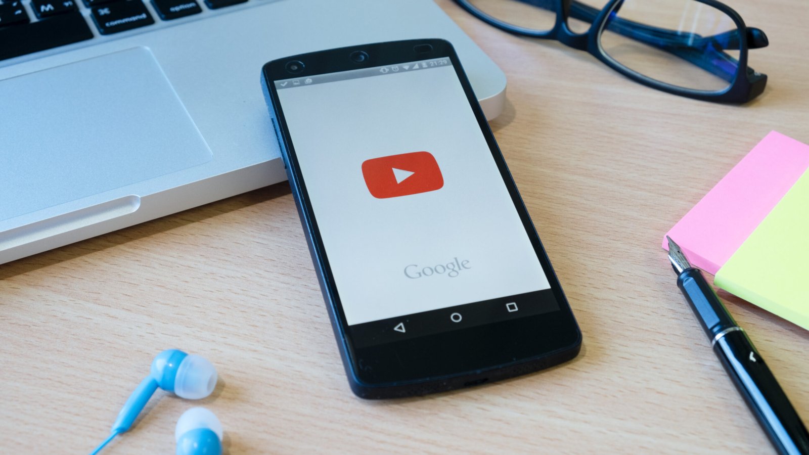 CHIANGMAI, THAILAND -FEBRUARY 7, 2017:LG Nexus 5 open YouTube app on the screen lying on desk with headphones. YouTube is the popular online video-sharing website.